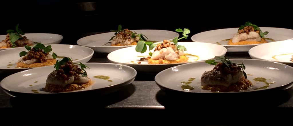 Plated dishes awaiting personal delivery to the dinner guests by the chefs.